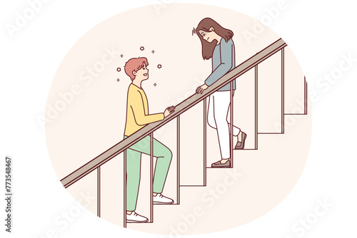 Woman with head down goes down stairs and positive man is waiting for beloved girlfriend downstairs. Teenager in love wants to meet girl whom he met when he climbed stairs