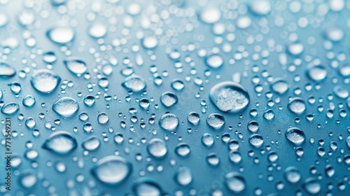 Close-up of water droplets on a blue surface with light reflections