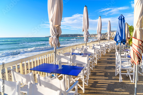 A seaside outdoor cafe along the Plage du Casino, the sandy beach along the Mediterranean Sea at the seaside resort town of Menton, France, along the Cote d'Azur French Riviera.