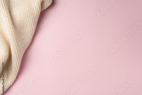 Pink background with knitted scarf. Copy space