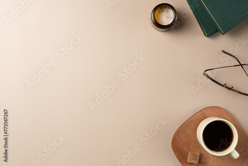 Book, glasses, candle, with cup coffee on beige background. Leisure concept, reading a book. Flat lay, top view