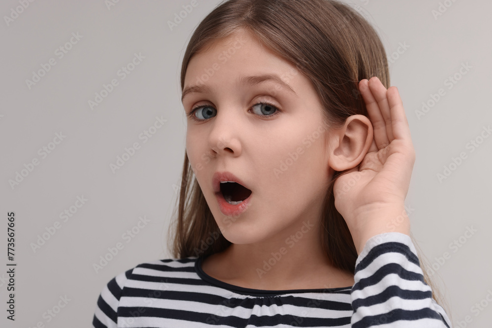 Little girl with hearing problem on grey background Little girl with hearing problem on grey background