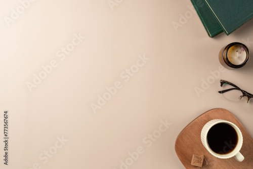 Book, glasses, candle, with cup coffee on beige background. Leisure concept, reading a book. Flat lay, top view