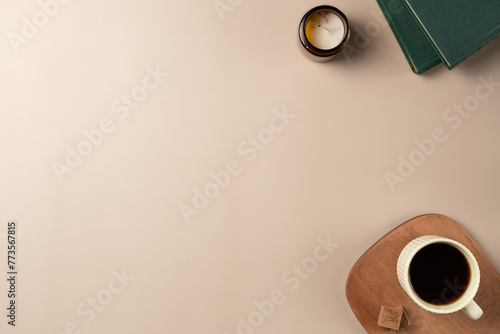 Book, glasses, candle, with cup coffee on beige background. Leisure concept, reading a book. Flat lay, top view