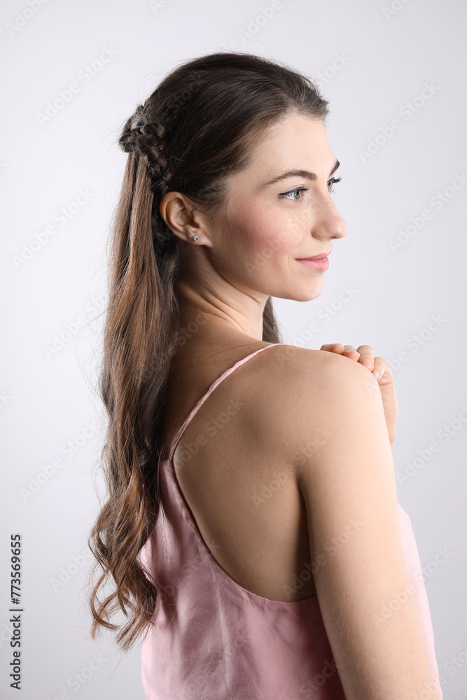 Woman with wavy hair on light background