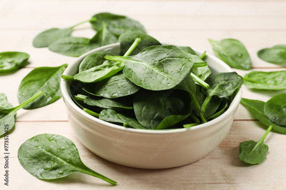 Fresh spinach leaves on light wooden table, closeup Fresh spinach leaves on light wooden table, closeup