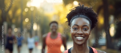 Young cheerful female with a happy expression strolling down a urban road while wearing a vibrant pink sleeveless top and black shorts photo