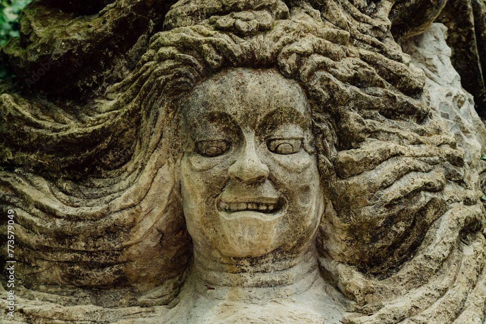 Stone sculpture of a face in Monkey Forest. Ubud, Bali, Indonesia.