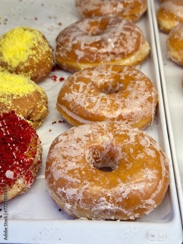 Assortment of glazed and sugar-coated donuts on display