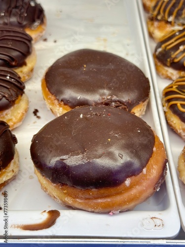Fresh chocolate glazed donuts on display