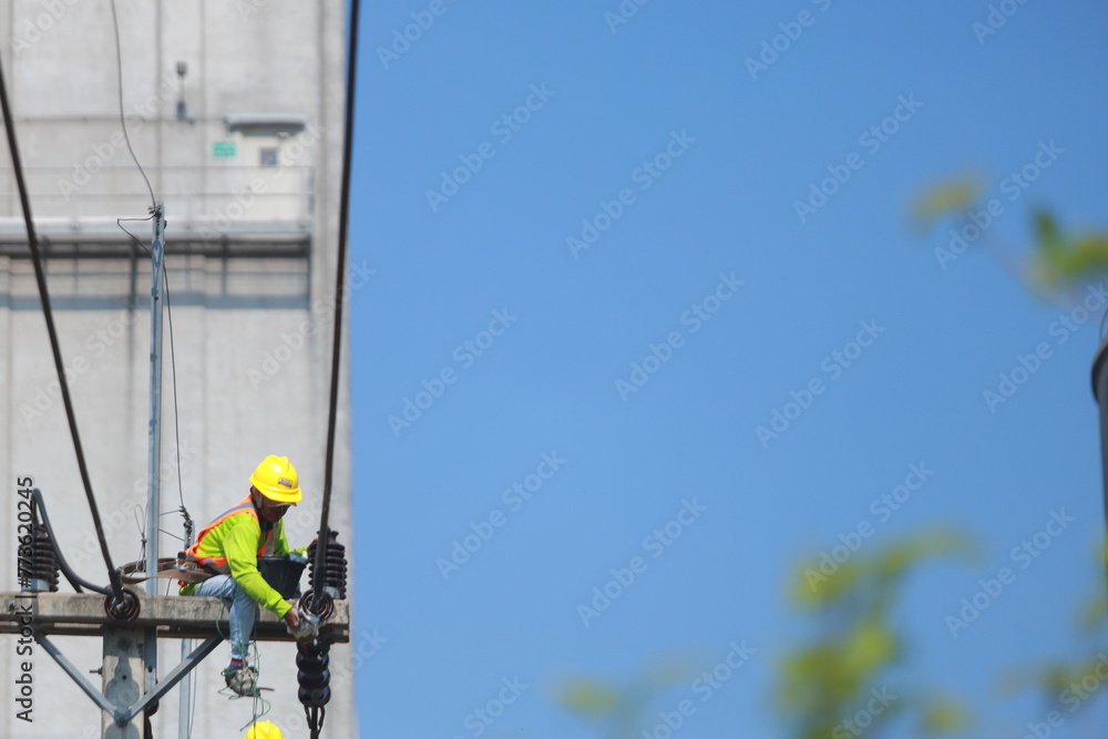 Asian man working on a power line Asian man working on a power line