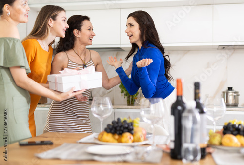 Girl celebrates her birthday  greets guests at home  arranges house party. Birthday girl accepts congratulations from three women guest  and thanks for pleasant surprise.