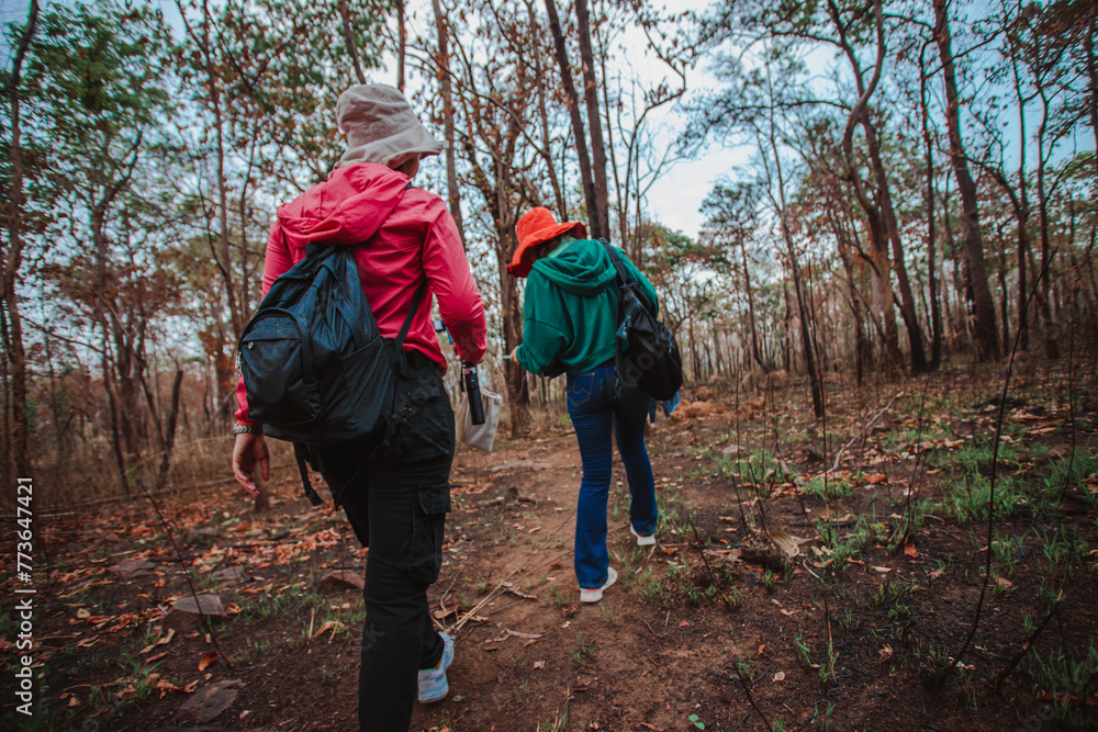 Obraz premium Young woman carries a bag and travels in the natural forest With the morning sun shining concept of tourism 