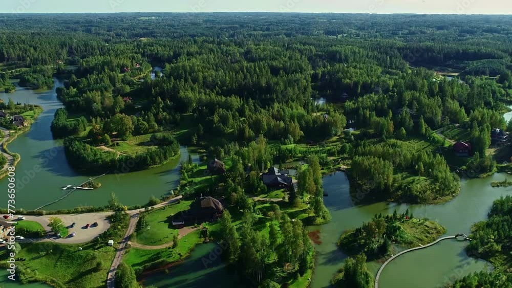 Bird-eye view over a green landscape with forests and lakes with country houses in between Bird-eye view over a green landscape with forests and lakes with country houses in between