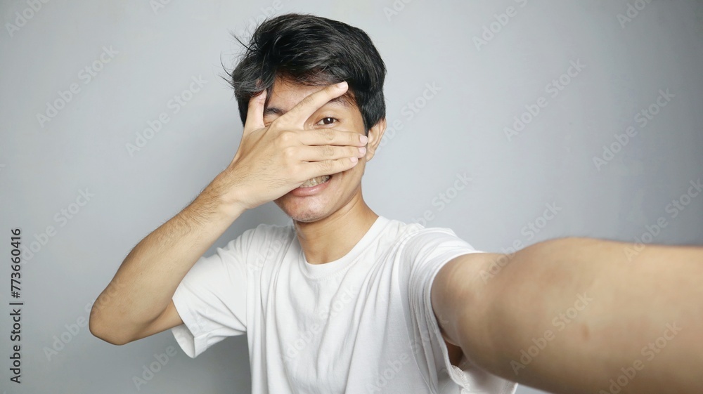 Young Asian man is taking a selfie with his camera Young Asian man is taking a selfie with his camera