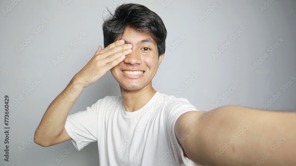 Young Asian man is taking a selfie with his camera Young Asian man is taking a selfie with his camera