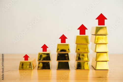 Stack gold bars as increase chart on wooden table with white background copy space. Investment in commodity market trading, risk mnagement concept. Gold is safe haven in economy crisis, war.