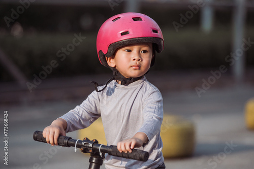 Photo of Asian Child pratice riding bicycle in the park outdoor 