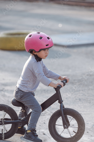 Portrait of Asian child with a pink helmet riding bike 