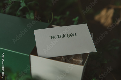 Photo of Thank You Card printed on the white paper with copy space on the grass 