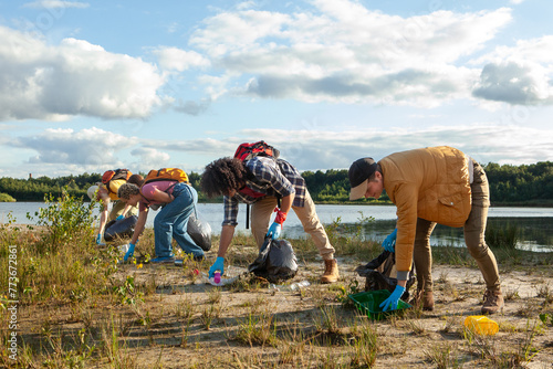 A diligent team works together to clean a lake's shore, contributing to environmental conservation. Group Effort in Lakeside Cleanup by Eco-Conscious Volunteers. High quality photo