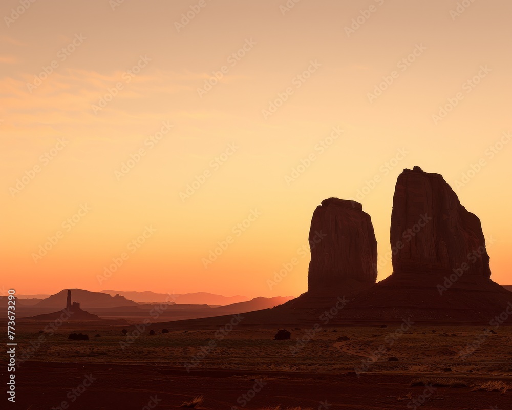 Two stone monoliths are silhouetted against a backdrop of a beautiful sunset