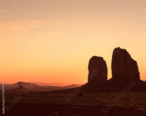 Two stone monoliths are silhouetted against a backdrop of a beautiful sunset