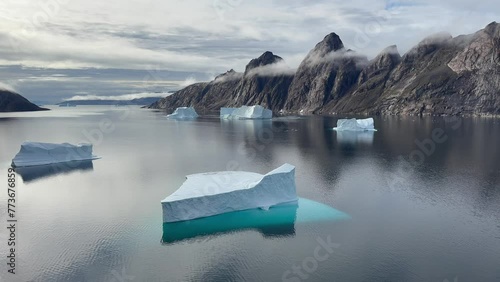 Static view of the fjord with a triangular iceberg at Bear Islands. Scoresbysund, Greenland. photo