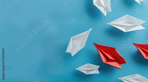 Formation of White Paper Vessels Interrupted by Solitary Red Ship photo