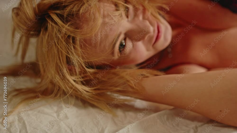 Close up of a attractive young woman laying in bed and playing with her beautiful blond hair Close up of a attractive young woman laying in bed and playing with her beautiful blond hair