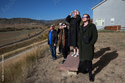 People wearing protective glasses looking at the sun during a solar eclipse