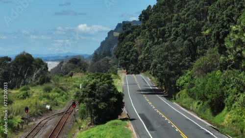 Aerial: Country road, traffic and pohutukawa grove near Pikowai, Bay of Plenty, New Zealand. photo