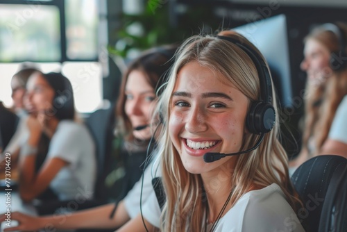 Group of happy call center employees. Cheerful call center employee with colleagues, working with headsets in a lively office atmosphere