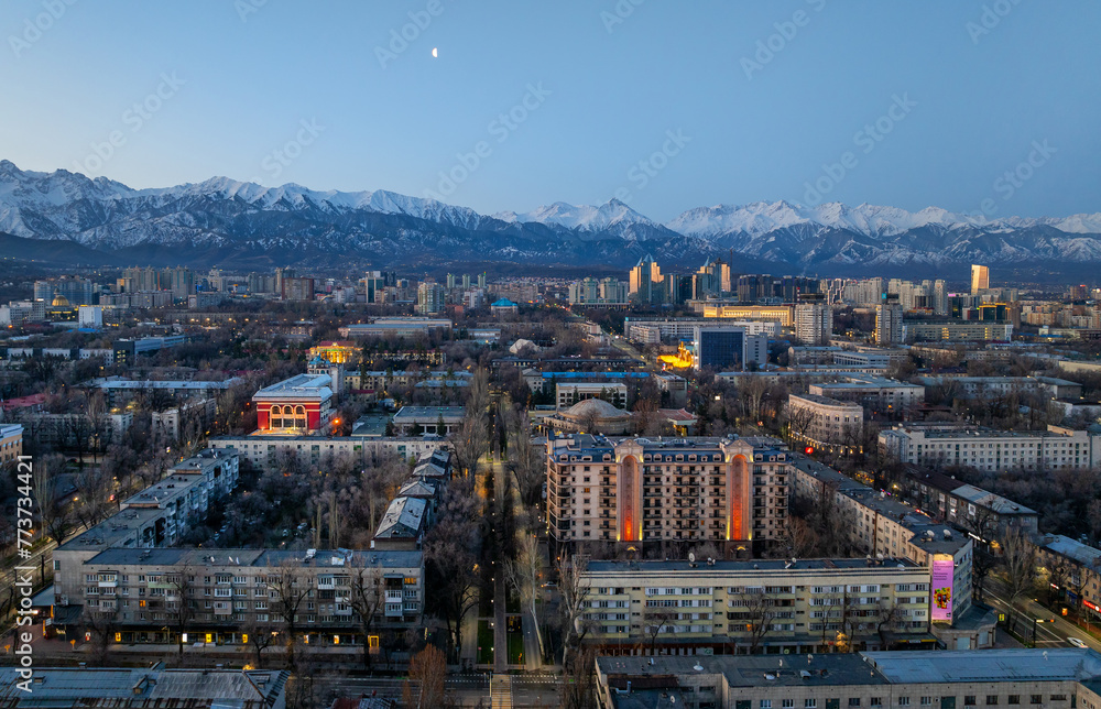 View from a quadcopter of the central part of the largest city of Kazakhstan - Almaty in the early spring morning against the backdrop of the Trans-Ili Alatau mountain range