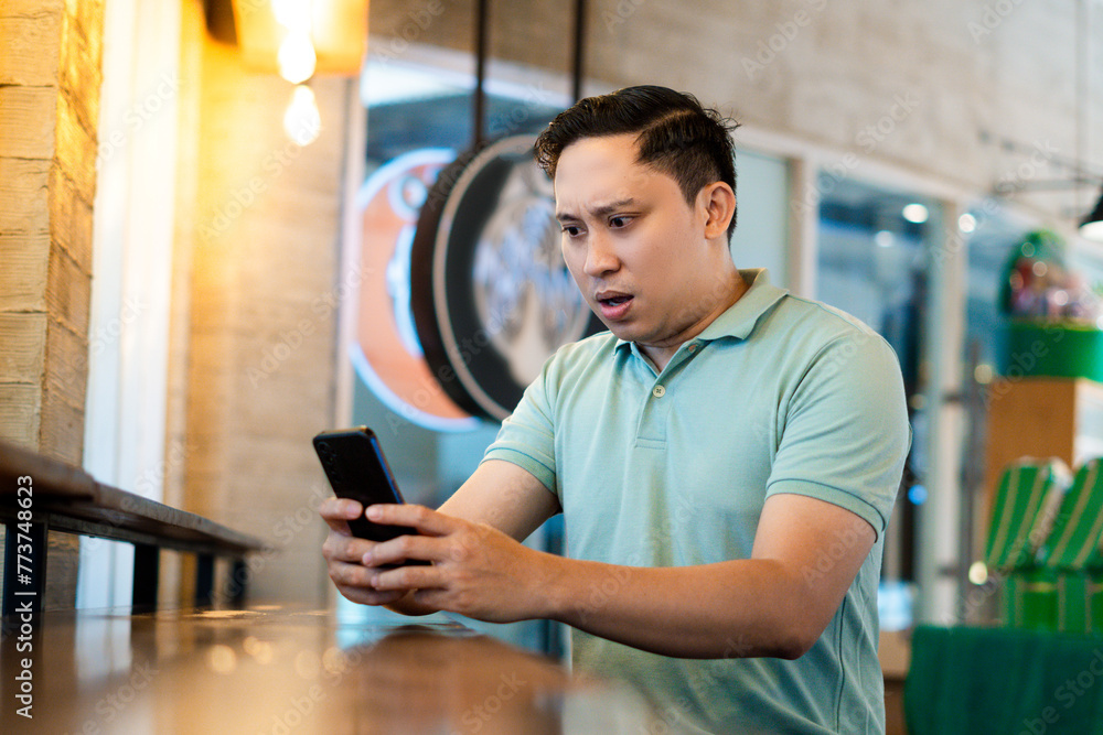 Adult man Angry and shocked over something on his phone Adult man Angry and shocked over something on his phone