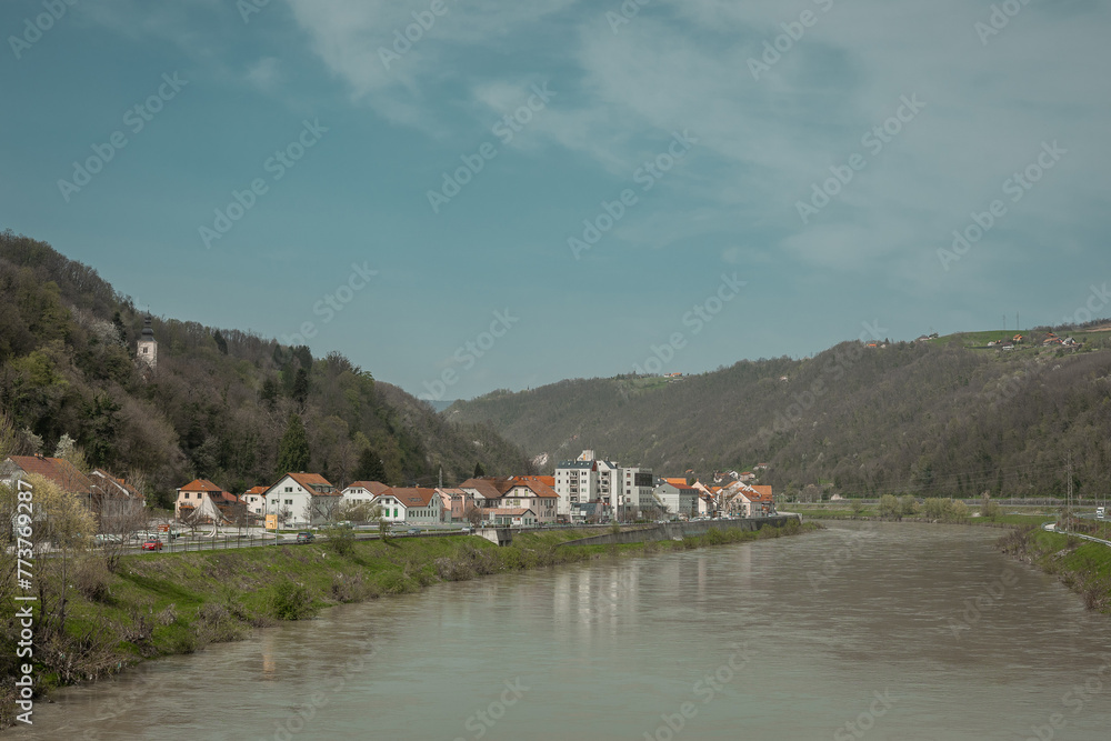 Panorama of the old town of Krsko on right Sava river bank. Looking from the road bridge connecting both sides. Sunny spring day in March