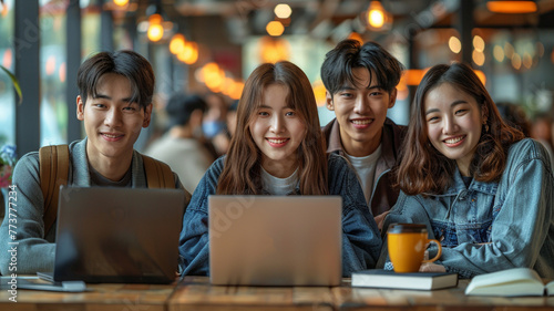 Team of Asian students using laptop computers in a modern student classroom.