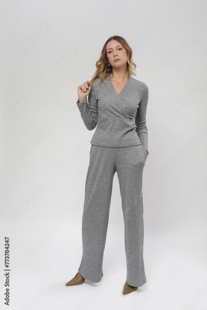 Serie of studio photos of female model in knitted grey set, autumn winter fashion collection. Serie of studio photos of female model in knitted grey set, autumn winter fashion collection.