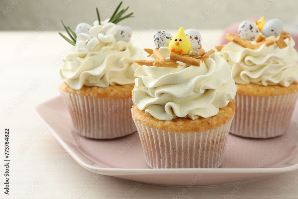 Tasty Easter cupcakes with vanilla cream on light wooden table, closeup Tasty Easter cupcakes with vanilla cream on light wooden table, closeup