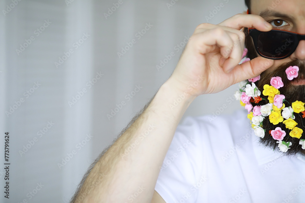 A bearded man with a decorated beard for the Spring holiday. Flowers in the beard. A bearded man with a decorated beard for the Spring holiday. Flowers in the beard.