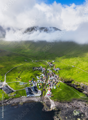 Drone view of Village of Gjogv on Faroe Islands with colourful houses. Mountain landscape with ocean coast photo