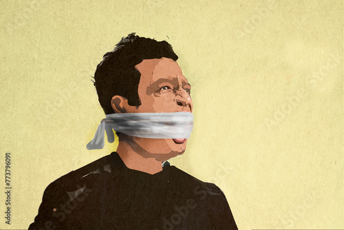 Man with mouth gagged by cloth against yellow background photo