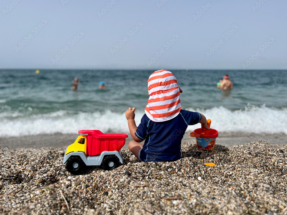 Little boy playing sitting on the sand at the beach Little boy playing sitting on the sand at the beach