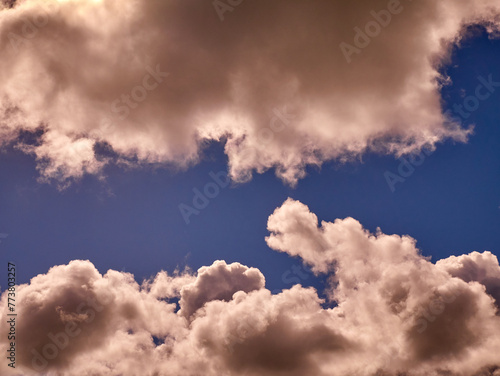 White cumulus clouds in the deep blue summer sky. Fluffy clouds background
