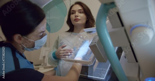 Healthy Female Does Cancer Prevention Routine in Hospital Room. In the Hospital, Mammography Technologist. Doctor Pushes Button on Mammogram Machine Activating Female Patient Scan. photo