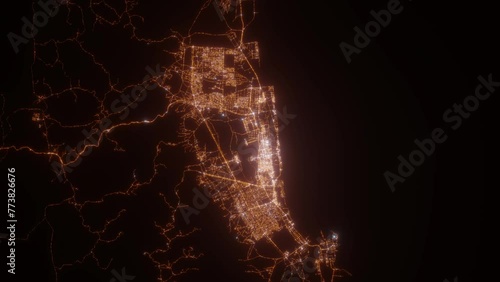 Salalah (Oman) top view at night. Top view on modern city with street lights and glow effect. Camera is zooming in, rotating clockwise. Vertical video. The north is on the left side photo