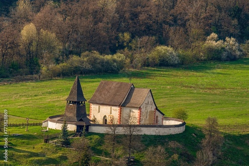 Gothic church of St Martin in Cerin village in spring. Slovakia. Fortified area of an old Gothic church with valuable frescoes. In the background the mountains and hills of the Great Fatra Europe. photo