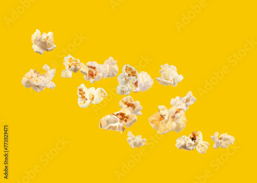 Tasty fresh popcorn flying on yellow background