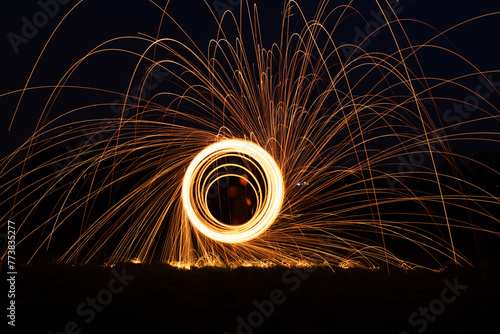 Abstract background of steel wool fireworks. Showers of glowing sparks from spinning steel wool. Steelwool in the night. photo