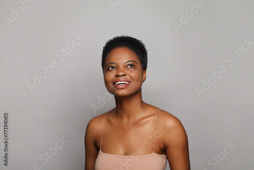 Gorgeous wellness model woman with dark shiny skin and cute smile looking up close-up portrait.